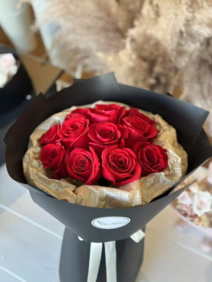 11 Red roses in black round packaging