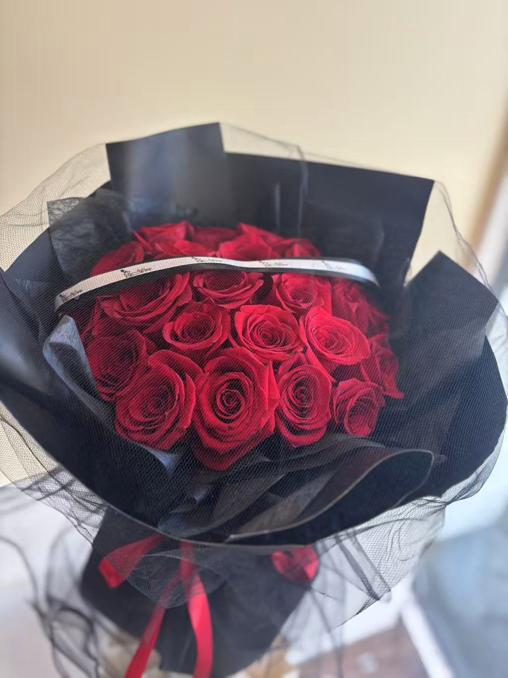 24 red roses bouquet with black mesh wrapping